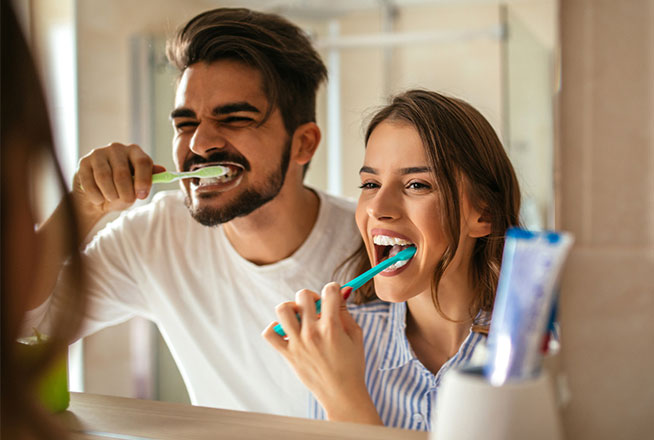 Un jeune couple se brosse les dents